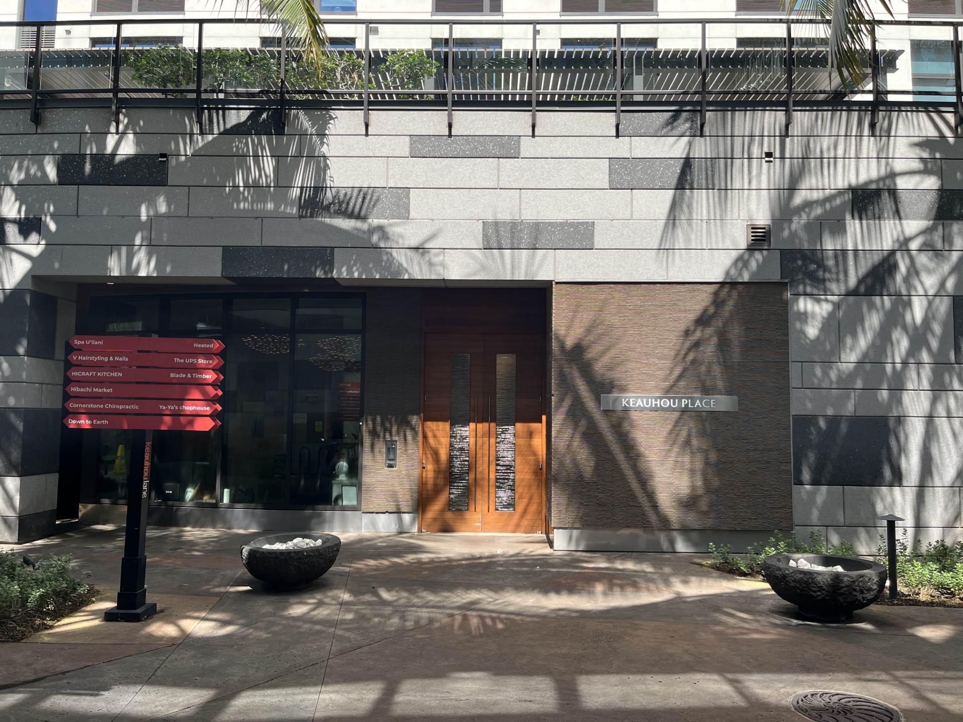 The image shows a building entrance with a red signboard and a brown door.